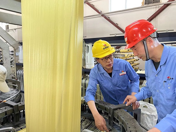 1653620936533051.jpeg 圓織機技術升級改造攻關組在現(xiàn)場研究圓織機潤滑技術照片.jpg