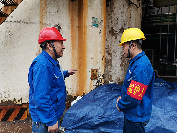3月31日上午，在一期鍋爐舊脫硫塔底部清理現(xiàn)場，安全員焦路秦對監(jiān)護人岳維哲的提問。.jpg