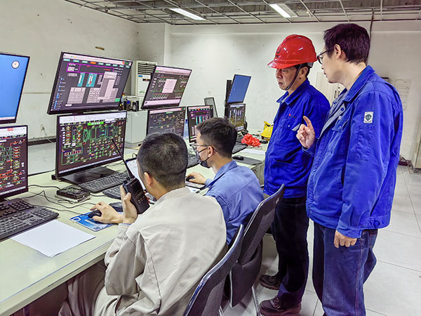 5月13日，動力車間三期鍋爐控制室，DCS改造工藝、儀表、電氣等部門聯(lián)合調(diào)試，車間主任姜軍虎與技術(shù)員畢加佳查看調(diào)試過程.jpg