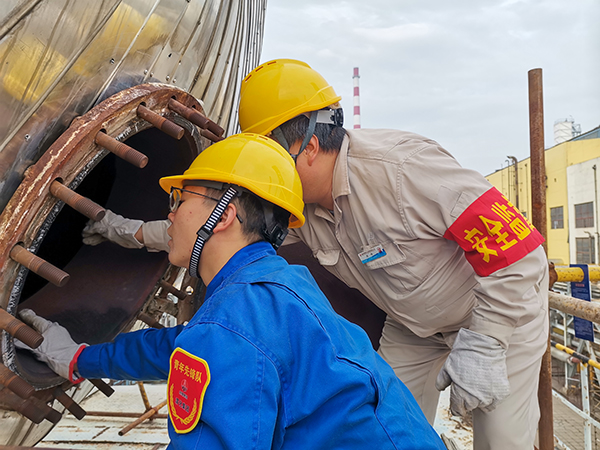 10月17日下午，在52工段除氧器人孔外，屈煒正在給董宇斌講述內(nèi)部構(gòu)造及工作原理。.jpg